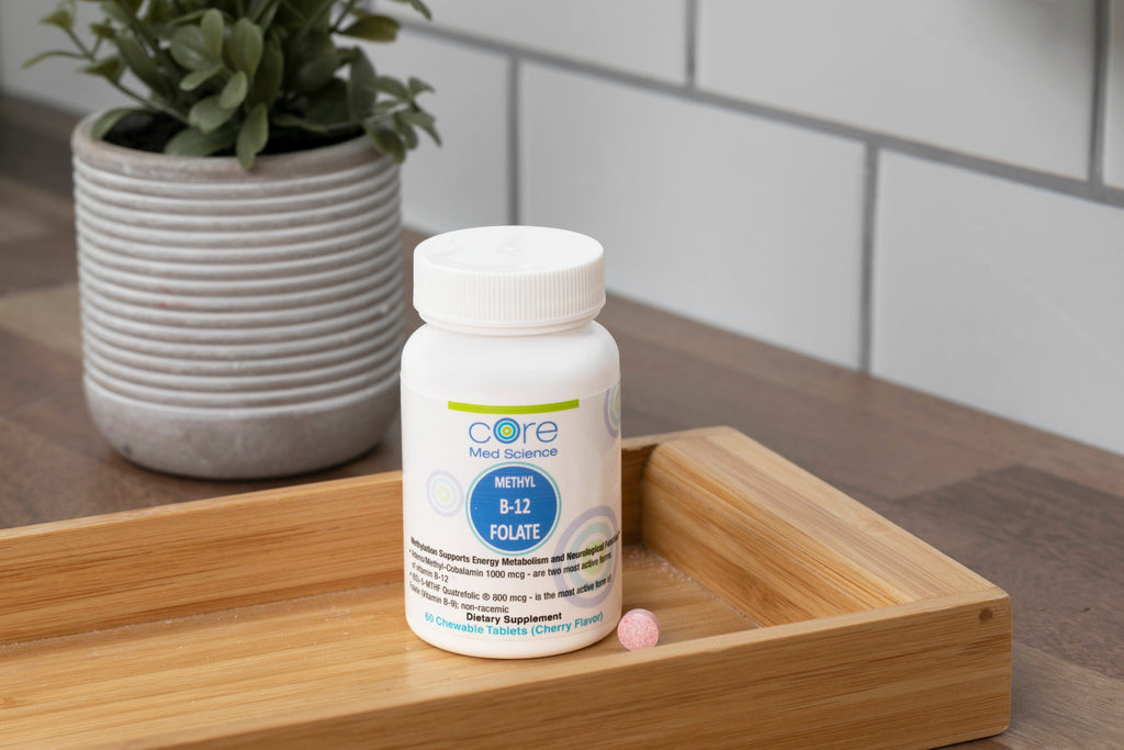 White bottle of Core Med Science Methyl B-12 Folate lozenges with blue label, displayed on wooden tray next to potted succule
