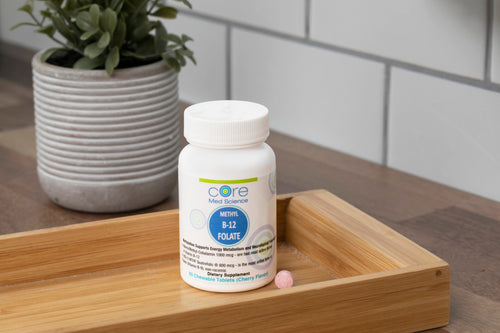 White bottle of Core Med Science Methyl B-12 Folate lozenges with blue label, displayed on wooden tray next to potted succule